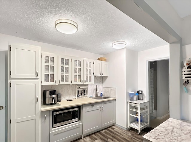 4085 SE 23rd Ter, Ocala, FL 34480 - kitchen with stainless steel microwave, dark wood-type flooring, light countertops, glass insert cabinets, and a textured ceiling
