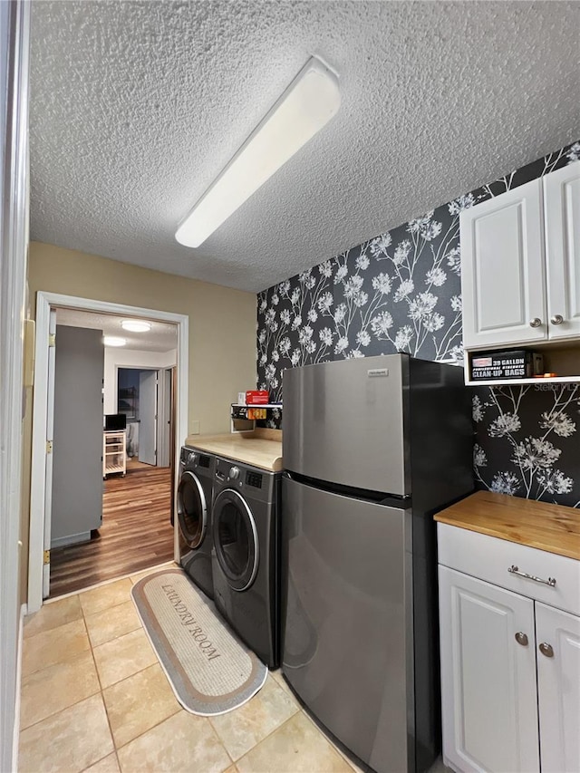 4085 SE 23rd Ter, Ocala, FL 34480 - laundry room with a textured ceiling, wallpapered walls, light tile patterned floors, and washing machine and dryer