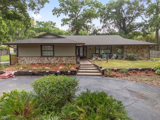 4085 SE 23rd Ter, Ocala, FL 34480 - ranch-style house featuring stone siding, roof with shingles, and covered porch