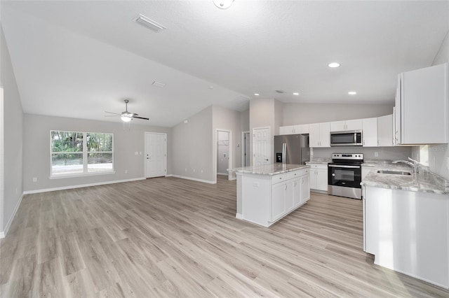 17654 SW 112th Ln, Dunnellon, FL 34432 - kitchen featuring a center island, baseboards, a sink, appliances with stainless steel finishes, and lofted ceiling