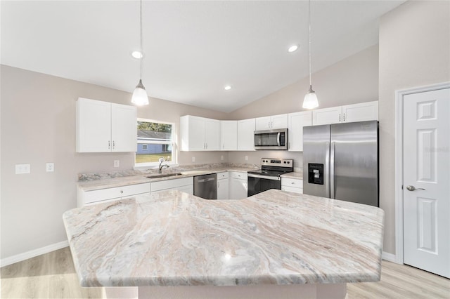 kitchen featuring white cabinets, a sink, light stone counters, and appliances with stainless steel finishes