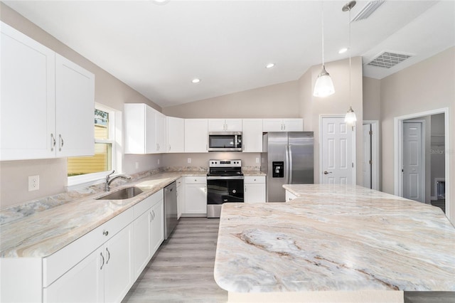 kitchen with vaulted ceiling, a center island, visible vents, stainless steel appliances, and a sink