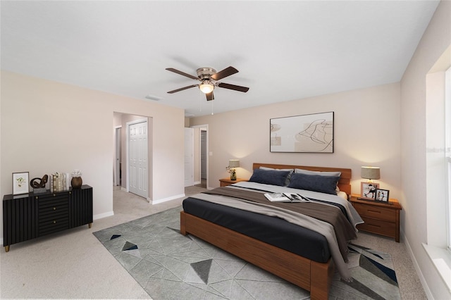 carpeted bedroom with visible vents, baseboards, and a ceiling fan