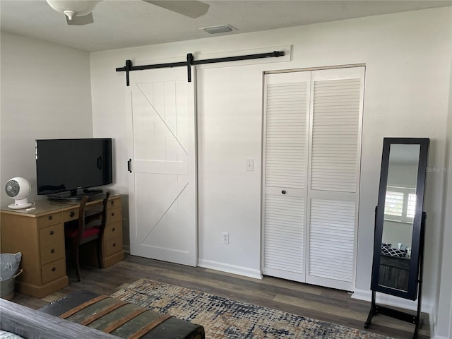 8533 SW 93rd Pl Unit A, Ocala, FL 34481 - bedroom featuring wood finished floors, a closet, a barn door, and a ceiling fan