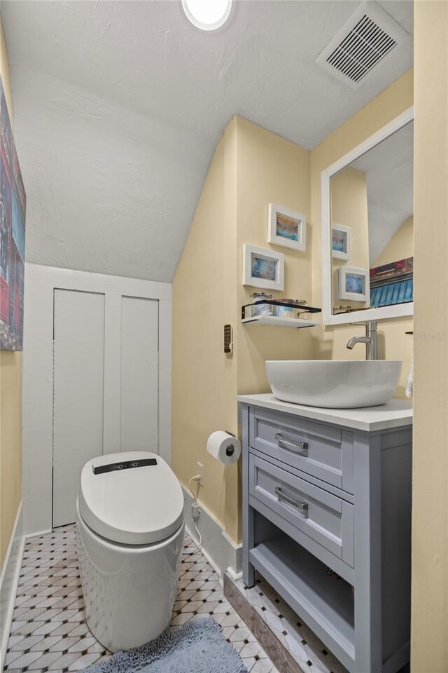 44 SE 9th Ter, Ocala, FL 34471 - bathroom with vaulted ceiling, toilet, vanity, tile patterned flooring, and visible vents