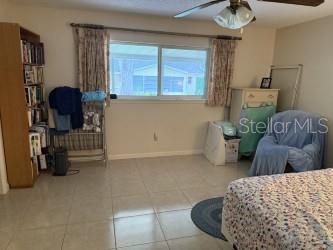 8665 SW 94th St Unit C, Ocala, FL 34481 - tiled bedroom with baseboards and a ceiling fan