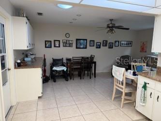8665 SW 94th St Unit C, Ocala, FL 34481 - kitchen featuring light tile patterned floors, white cabinetry, and ceiling fan