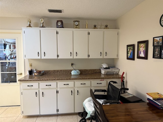 8665 SW 94th St Unit C, Ocala, FL 34481 - kitchen with white cabinetry, dark countertops, light tile patterned floors, and a textured ceiling