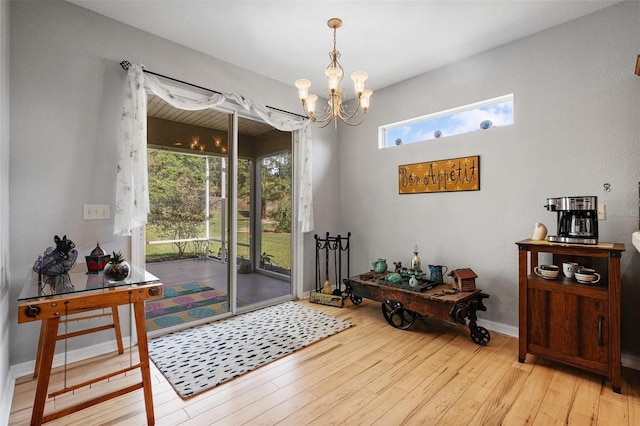 doorway to outside featuring wood-type flooring, baseboards, and a notable chandelier