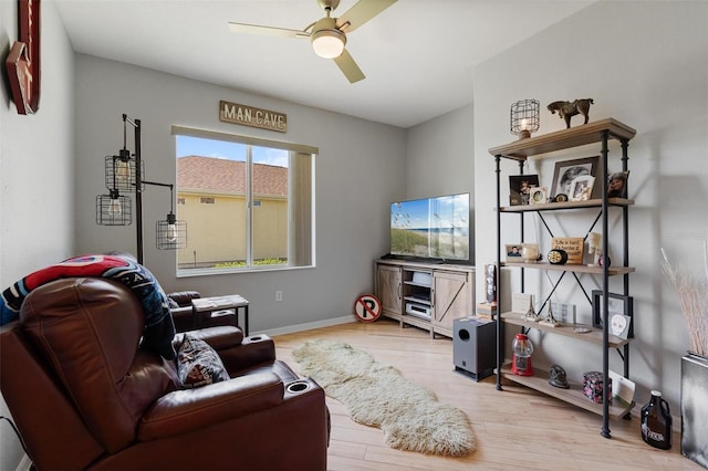 living area with ceiling fan, wood finished floors, and baseboards