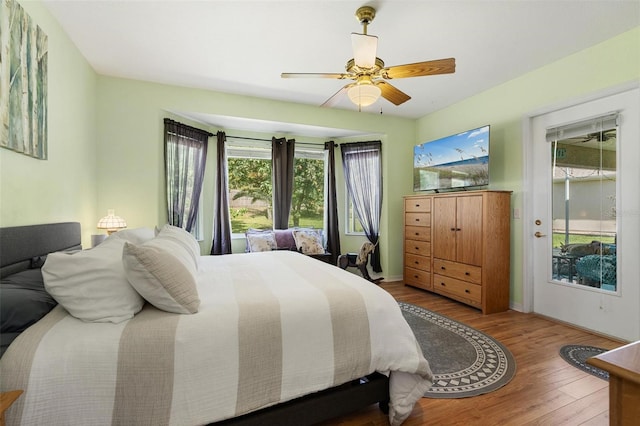 bedroom with ceiling fan, access to exterior, and wood finished floors