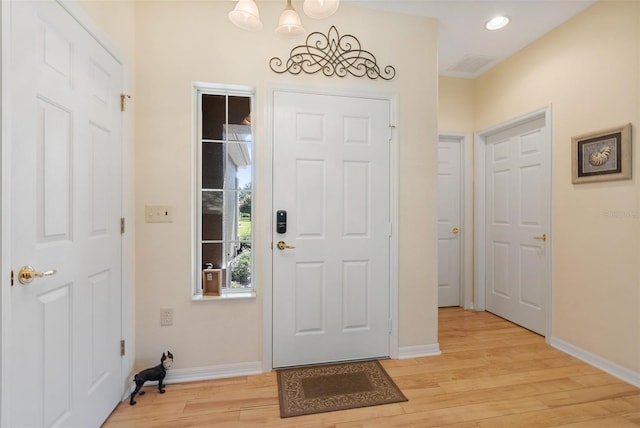 foyer featuring a chandelier, recessed lighting, light wood-style flooring, and baseboards