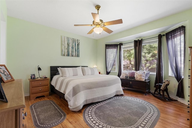 bedroom with wood finished floors, baseboards, and a ceiling fan