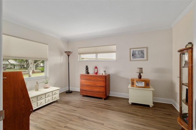 living area with a wealth of natural light, ornamental molding, and wood finished floors