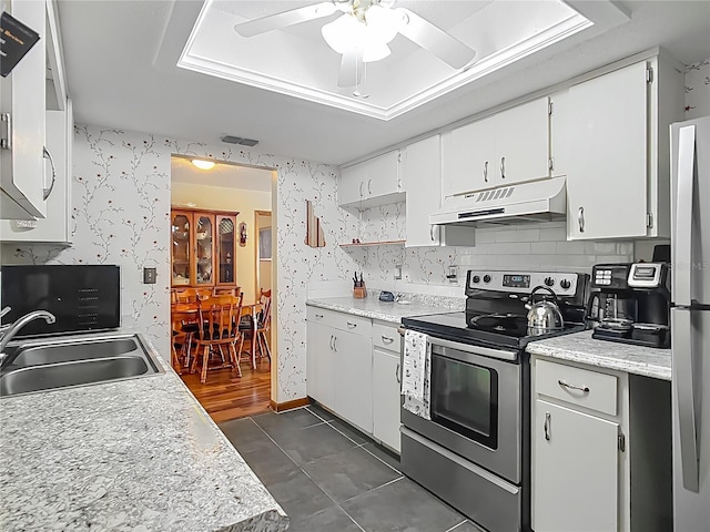 kitchen with a sink, ceiling fan, under cabinet range hood, wallpapered walls, and stainless steel appliances