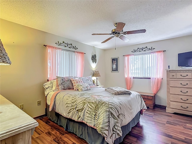 bedroom with ceiling fan, a textured ceiling, baseboards, and dark wood-style floors
