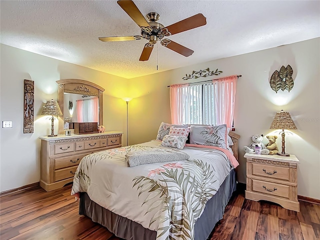 bedroom with dark wood-style flooring, a textured ceiling, baseboards, and ceiling fan