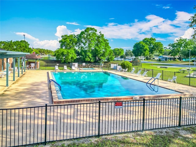 pool with a yard, fence, and a patio
