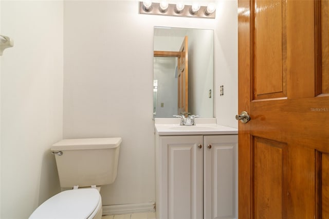 bathroom with baseboards, toilet, and vanity