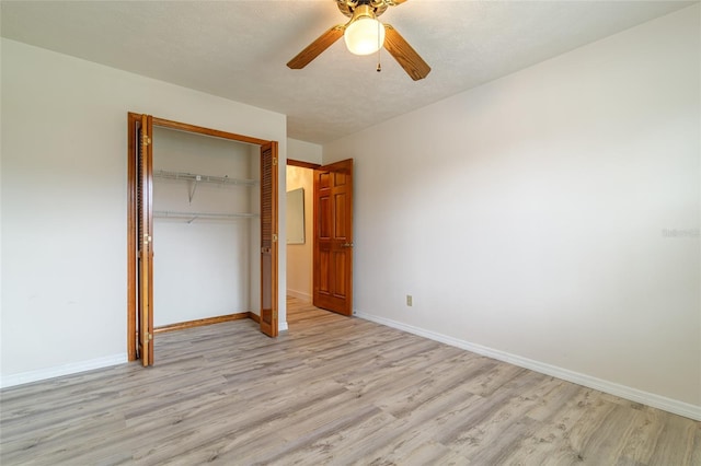 unfurnished bedroom featuring baseboards, a closet, light wood-style floors, and ceiling fan