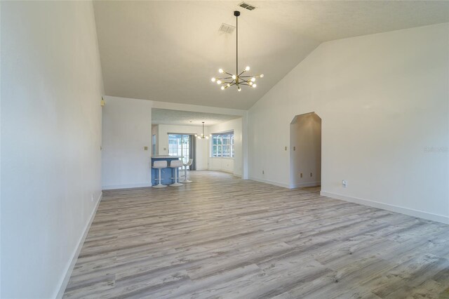 unfurnished room featuring an inviting chandelier, visible vents, baseboards, and wood finished floors
