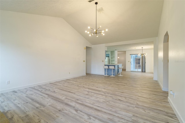 unfurnished living room featuring light wood-type flooring, an inviting chandelier, high vaulted ceiling, baseboards, and visible vents