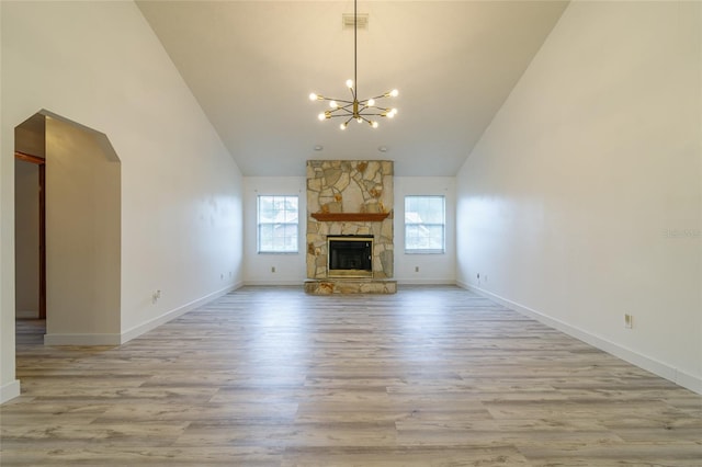 unfurnished living room with visible vents, high vaulted ceiling, wood finished floors, and a chandelier