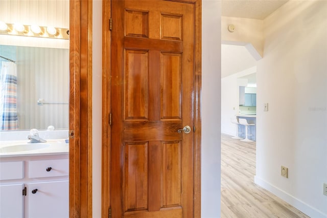 bathroom featuring baseboards, wood finished floors, vanity, and a shower with curtain