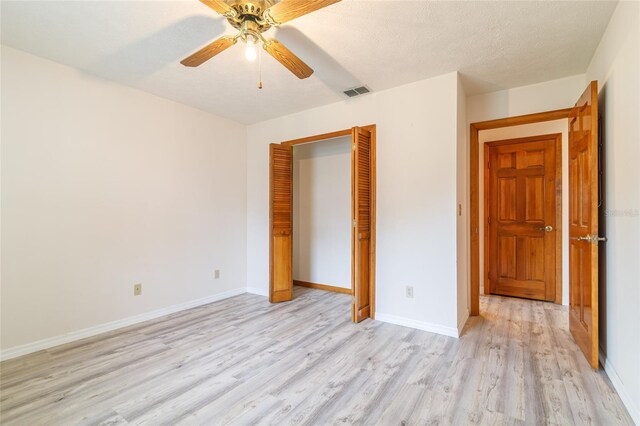 unfurnished bedroom with baseboards, ceiling fan, light wood-style flooring, visible vents, and a closet