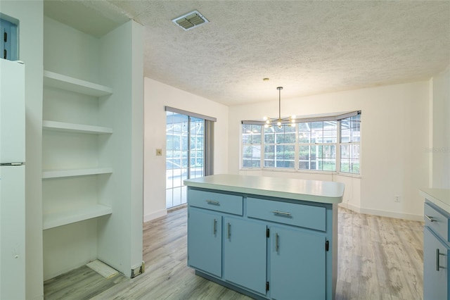 kitchen featuring blue cabinetry, a wealth of natural light, an inviting chandelier, and visible vents