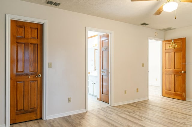 unfurnished bedroom with a textured ceiling, visible vents, and light wood-style floors