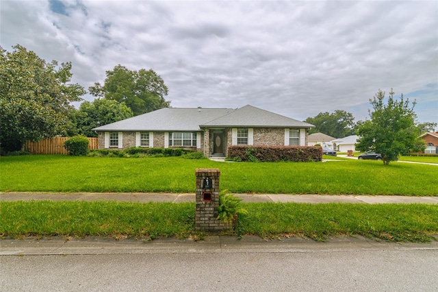 single story home with a front yard and fence