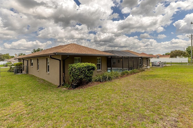 5770 SW 89th Pl, Ocala, FL 34476 - rear view of house with fence, a lawn, glass enclosure, and stucco siding