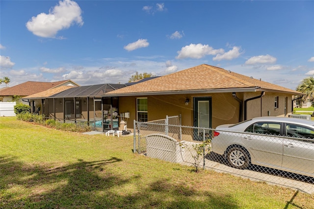 5770 SW 89th Pl, Ocala, FL 34476 - view of front of house featuring glass enclosure, a front lawn, fence, a shingled roof, and stucco siding