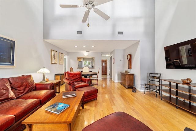living area with a ceiling fan, baseboards, light wood-style floors, and visible vents