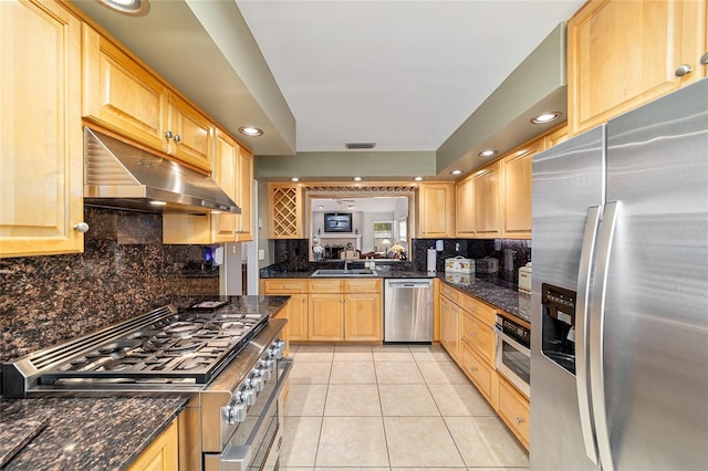 kitchen featuring light brown cabinets, appliances with stainless steel finishes, under cabinet range hood, light tile patterned floors, and visible vents