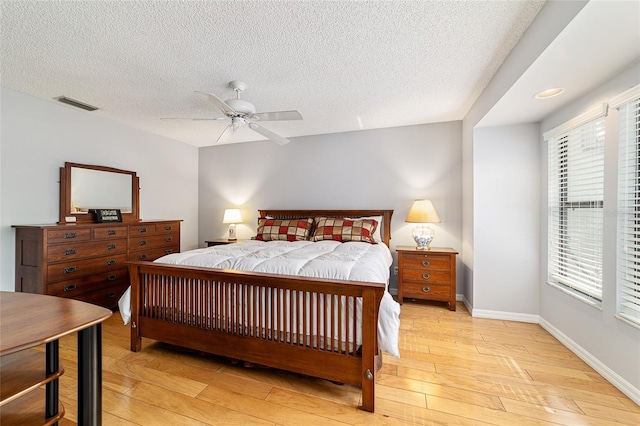bedroom featuring light wood-style flooring, baseboards, ceiling fan, and visible vents