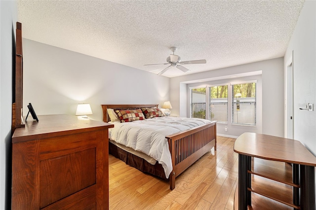 bedroom with light wood-style flooring, ceiling fan, and a textured ceiling