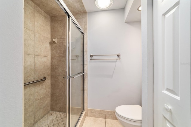 bathroom with toilet, a stall shower, and tile patterned floors