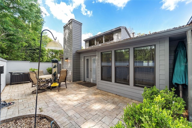 view of patio featuring outdoor dining area, french doors, and fence