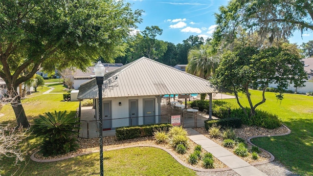 view of front of property featuring metal roof, a fenced front yard, a front yard, and a gate