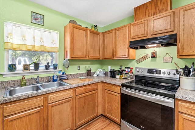 8570 N Discalfani Loop, Crystal River, FL 34428 - kitchen with light countertops, a sink, a textured ceiling, under cabinet range hood, and electric stove