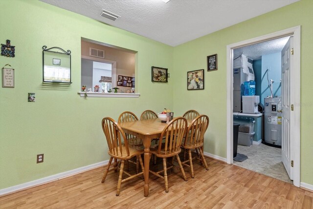 8570 N Discalfani Loop, Crystal River, FL 34428 - dining space with visible vents, wood finished floors, electric water heater, and a textured ceiling