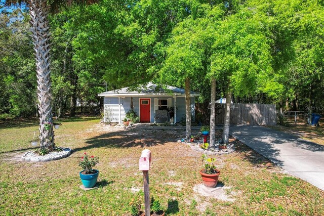 8570 N Discalfani Loop, Crystal River, FL 34428 - view of front of house with driveway, an outbuilding, fence, and a front yard