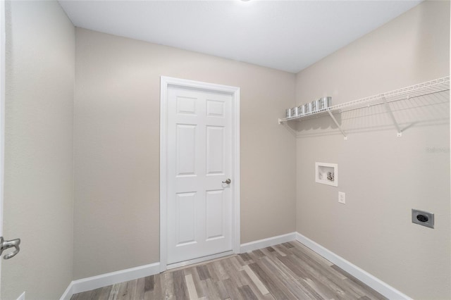 washroom featuring hookup for a washing machine, baseboards, laundry area, light wood-style floors, and hookup for an electric dryer