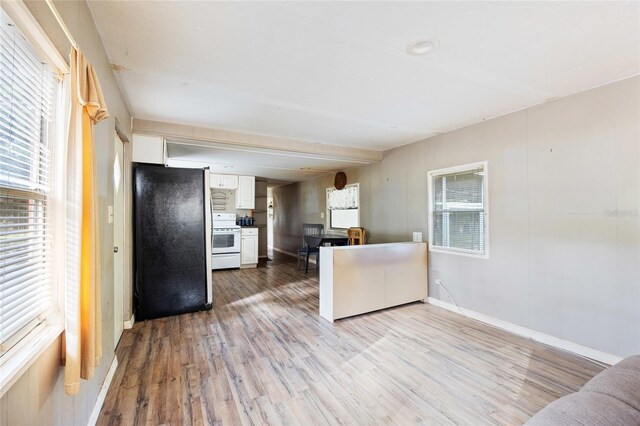 2780 County Road 575, Bushnell, FL 33513 - kitchen with baseboards, white cabinetry, light wood-type flooring, white range with electric cooktop, and freestanding refrigerator