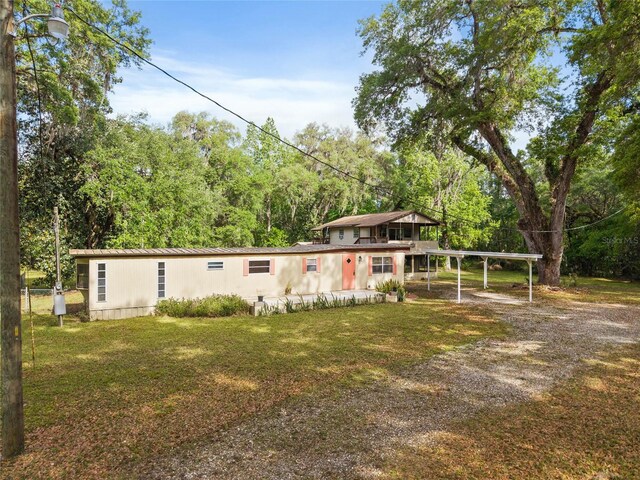 2780 County Road 575, Bushnell, FL 33513 - view of front of home with metal roof, driveway, a front yard, a carport, and a view of trees