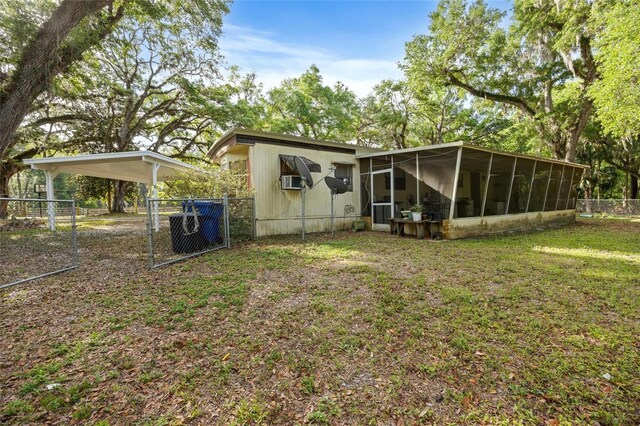 2780 County Road 575, Bushnell, FL 33513 - rear view of property with a sunroom, fence, a gate, a detached carport, and a yard