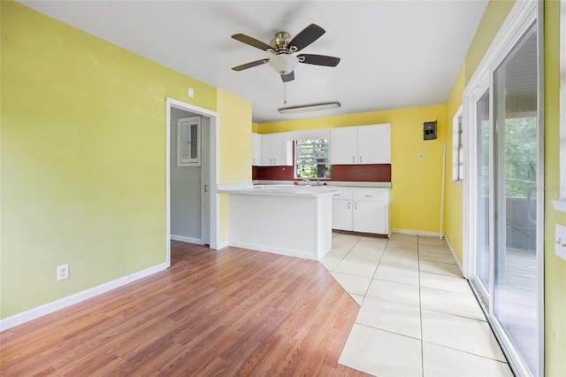2780 County Road 575, Bushnell, FL 33513 - kitchen with a ceiling fan, white cabinetry, a peninsula, light wood-type flooring, and baseboards