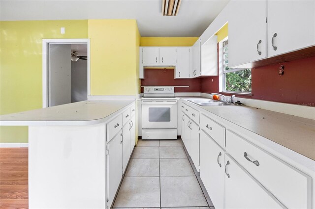 2780 County Road 575, Bushnell, FL 33513 - kitchen with white cabinets, light countertops, a peninsula, light tile patterned floors, and electric range